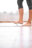 Close-up of legs of young woman with massage ball on wooden floor