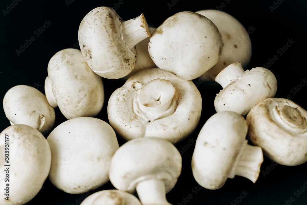 champignon mushrooms on a black background. space for text champignon mushrooms on a black background. space for text