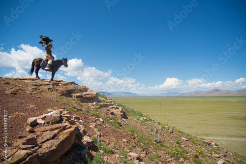 Kazakh eagle hunter on his horse in altai mountains, mongolia