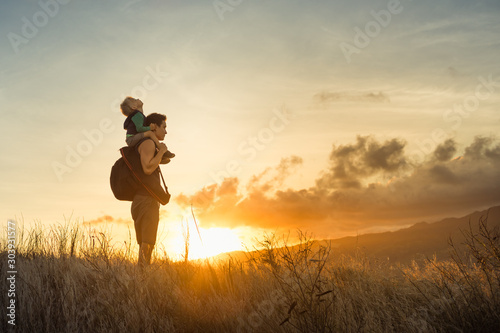Adventurous father and son standing on a mountain to looking at the beautiful view.  © kieferpix