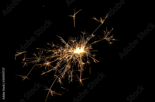 burning sparkler and flying sparks on a black background  festive sparkler