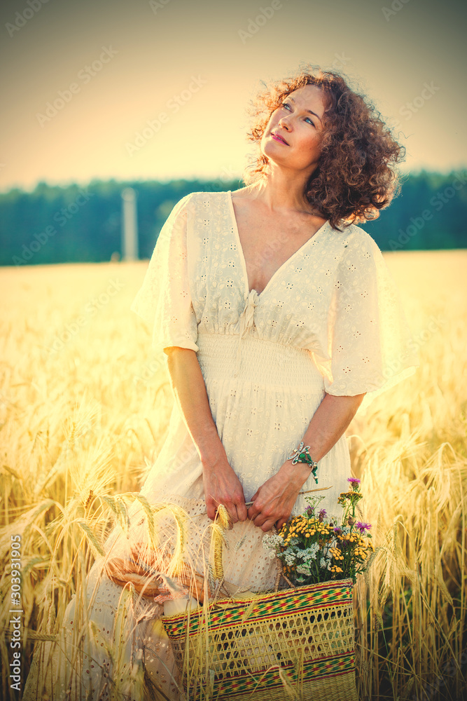Φωτογραφία beautiful smiling woman in a white dress standing among the ears of wheat