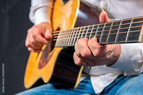 Man's hands playing acoustic guitar