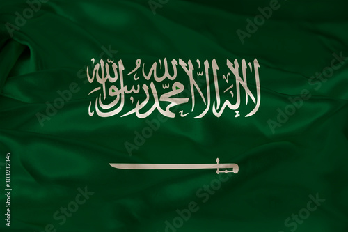 photo of the beautiful colored national flag of the modern state of Saudi Arabia on textured fabric, concept of tourism, economics and politics, closeup