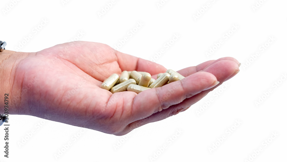 Hand holding herb capsule isolated on white background Hand holding herb capsule isolated on white background