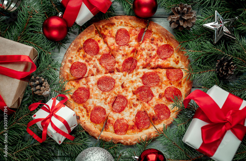 Christmas pepperoni pizza with Christmas decorations, gift, spruce, toys