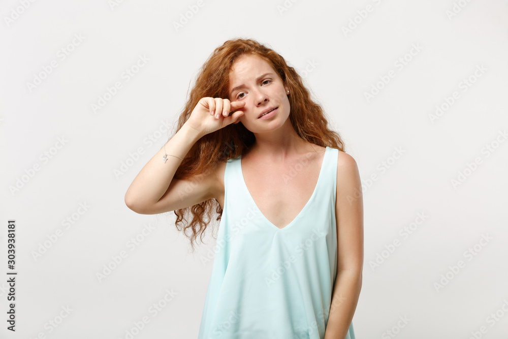Young displeased redhead woman girl in casual light clothes posing isolated on white background, studio portrait. People sincere emotions lifestyle concept. Mock up copy space. Crying, wiping tears. Young displeased redhead woman girl in casual light clothes posing isolated on white background, studio portrait. People sincere emotions lifestyle concept. Mock up copy space. Crying, wiping tears.