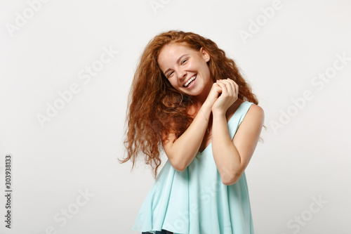 Young smiling funny redhead woman girl in casual light clothes posing isolated on white background studio portrait. People sincere emotions lifestyle concept. Mock up copy space. Holding hands folded.