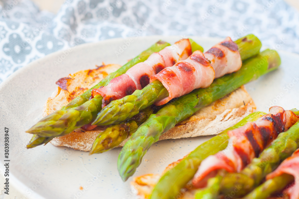 Grilled asparagus with bacon and slice of whole grain bread Grilled asparagus with bacon and slice of whole grain bread