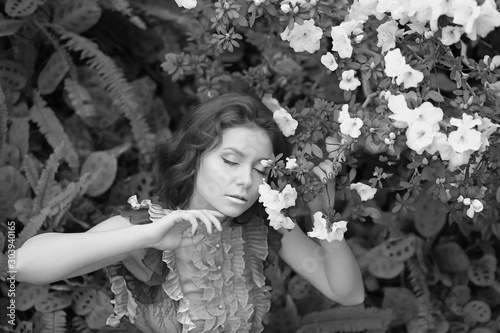  stunning black and white portrait beautiful  young model girl  in arranger where azalea blooms in a flying dress.  Beauty and Fashion