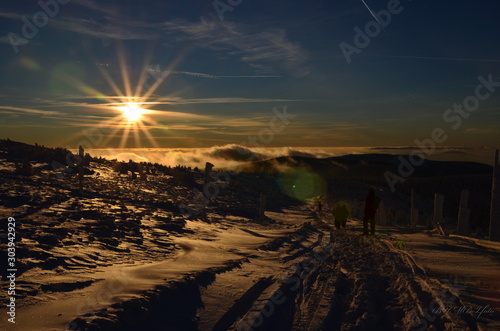 sunset on top of the hill covered by snow 