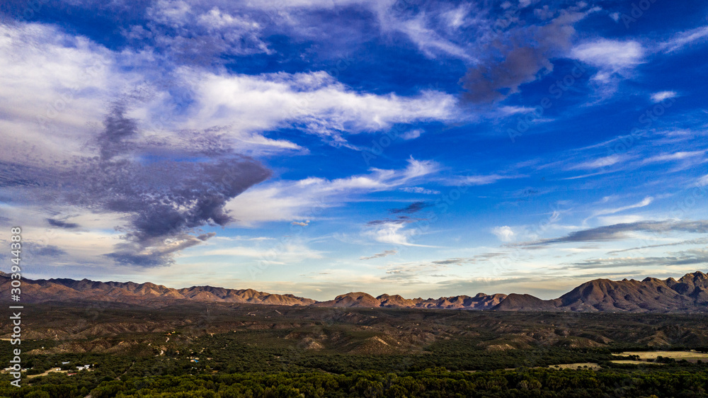 Sunset, aerial landscapes of Santa Rita Mountains from above Tubac, Arizona with warm , golden plains, purple mountains, blue sky with colorful clouds on a Fall day 