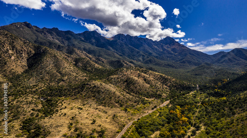 Aerial panorama of Madera Canyon in the Santa Rita Mountains, Arizona in the Fall with purple mountains, green, yellow, orange trees and bushes, blue sky photo