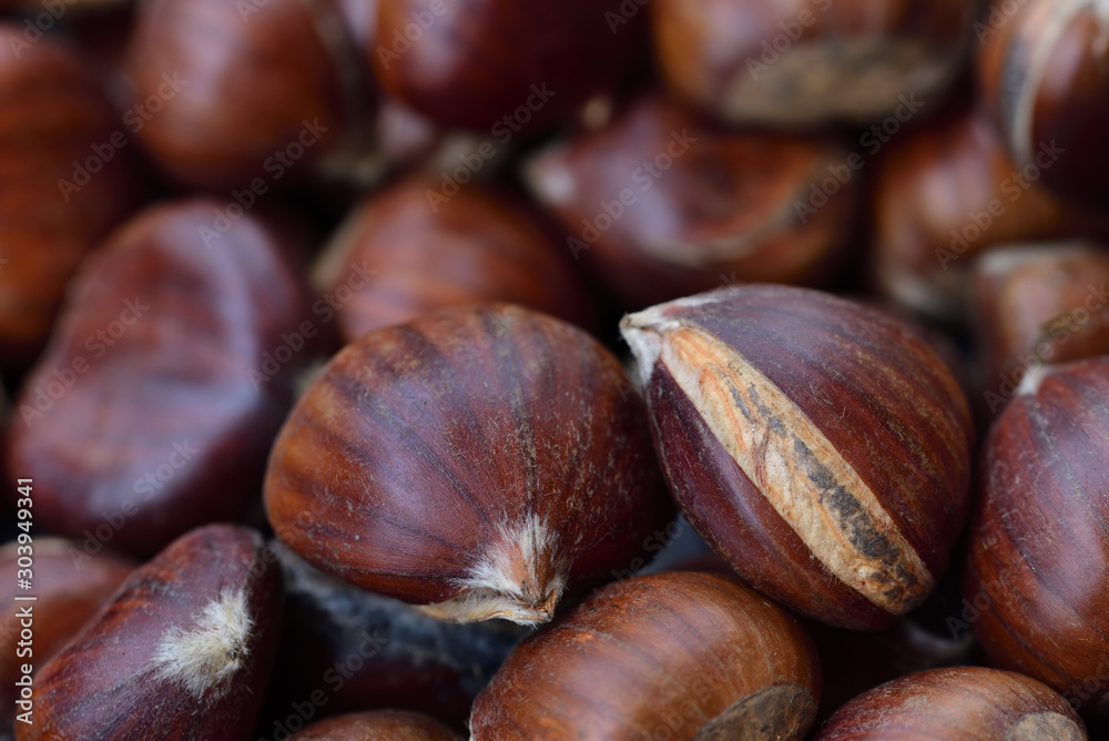 Obraz premium Background of fresh chestnuts with shell lying side by side
