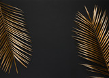 Gold painted palm leaf on black background isolated