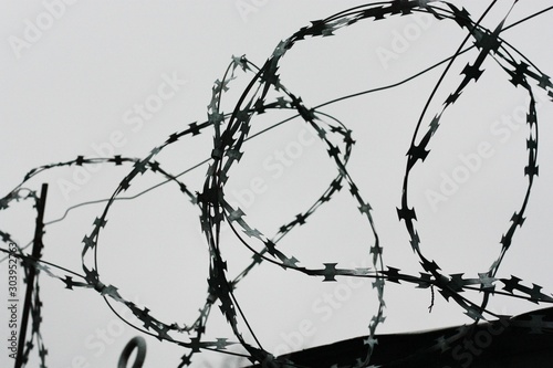 Barbed wire on concrete fence close up view