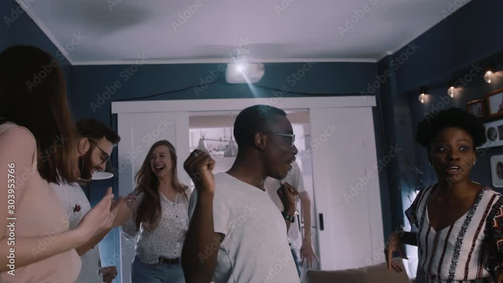 Cheerful young handsome happy African American student man dancing with friends at vacation holiday party slow motion.
