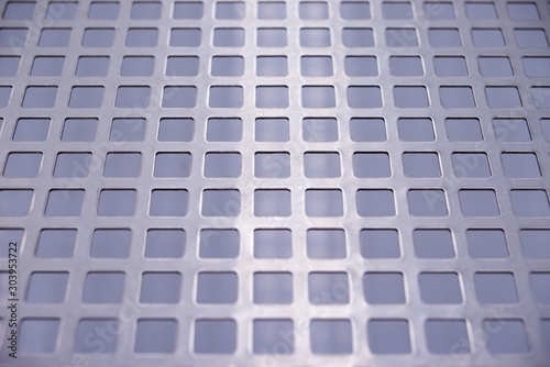 Perforated stainless metal sheet on white background. © venars.original