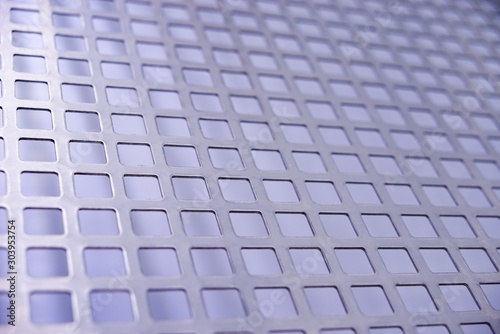 Perforated stainless metal sheet on white background.