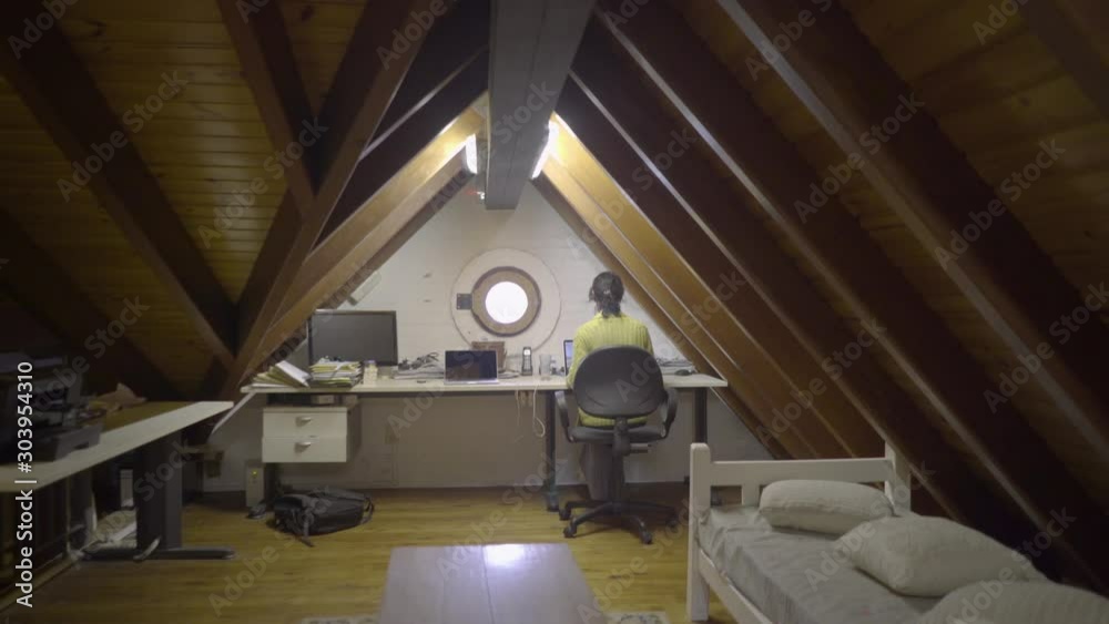 Woman works on laptop in her room. Back view. Woman works on laptop in her room. Back view.
