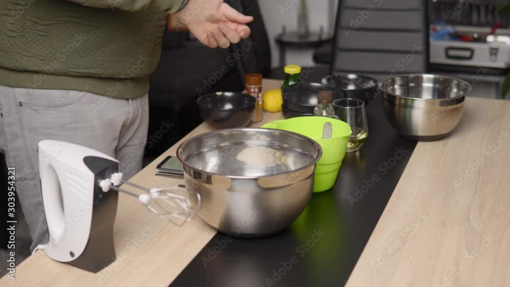 Static shot of a man putting ingredients in a bowl to prepare food. Static shot of a man putting ingredients in a bowl to prepare food.