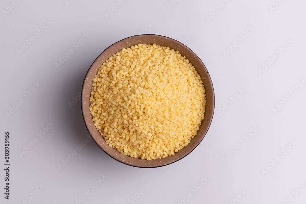 Dry couscous isolated on white background, soft light, copy space.