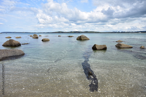 Shallow sandy shore with clear water and large stones near Ti Point in New Zealand. photo