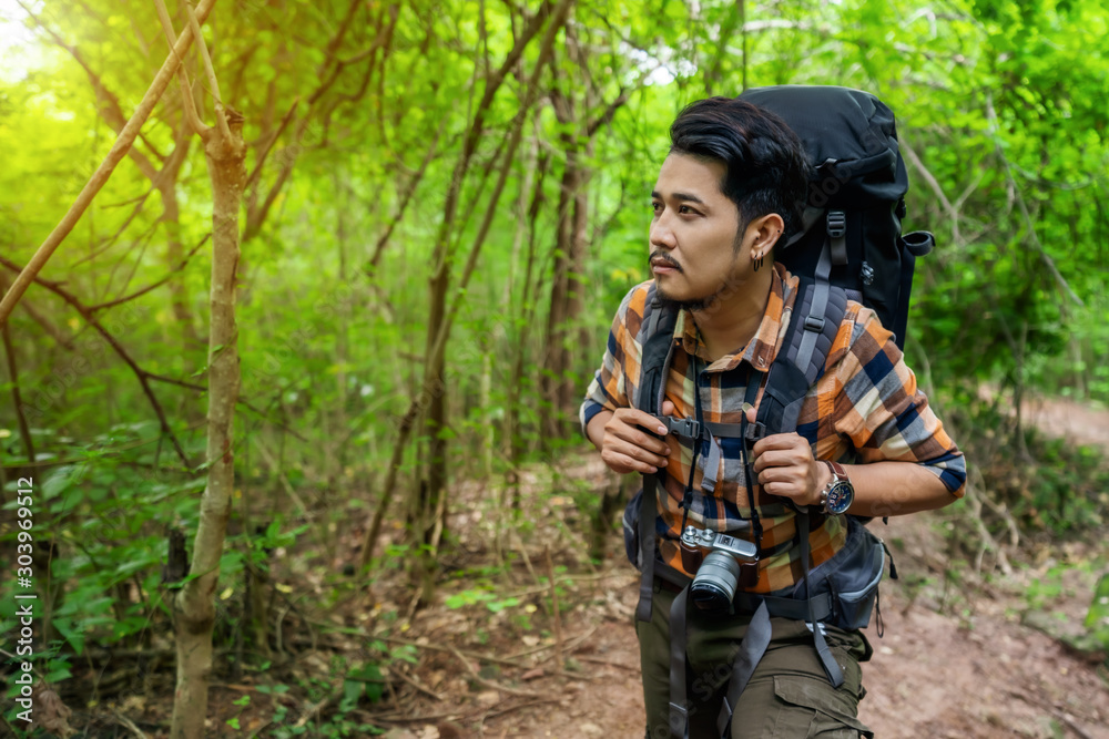 man traveler with backpack walking and looking in the forest man traveler with backpack walking and looking in the forest