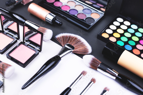 Creative beauty and makeup flat lay made with brushes, foundation, eye shadows and blush.