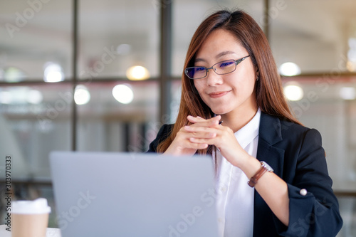 Closeup image of businesswoman looking at laptop while working in office