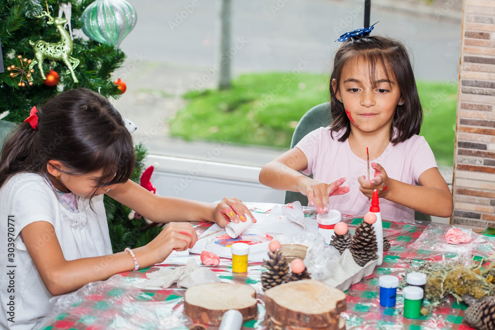 Two little sisters having fun while making christmas Nativity crafts with at home - Real family Two little sisters having fun while making christmas Nativity crafts with at home - Real family