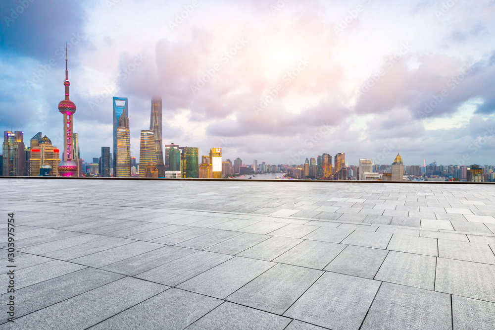 Empty square floor and modern cityscape in Shanghai at sunset.