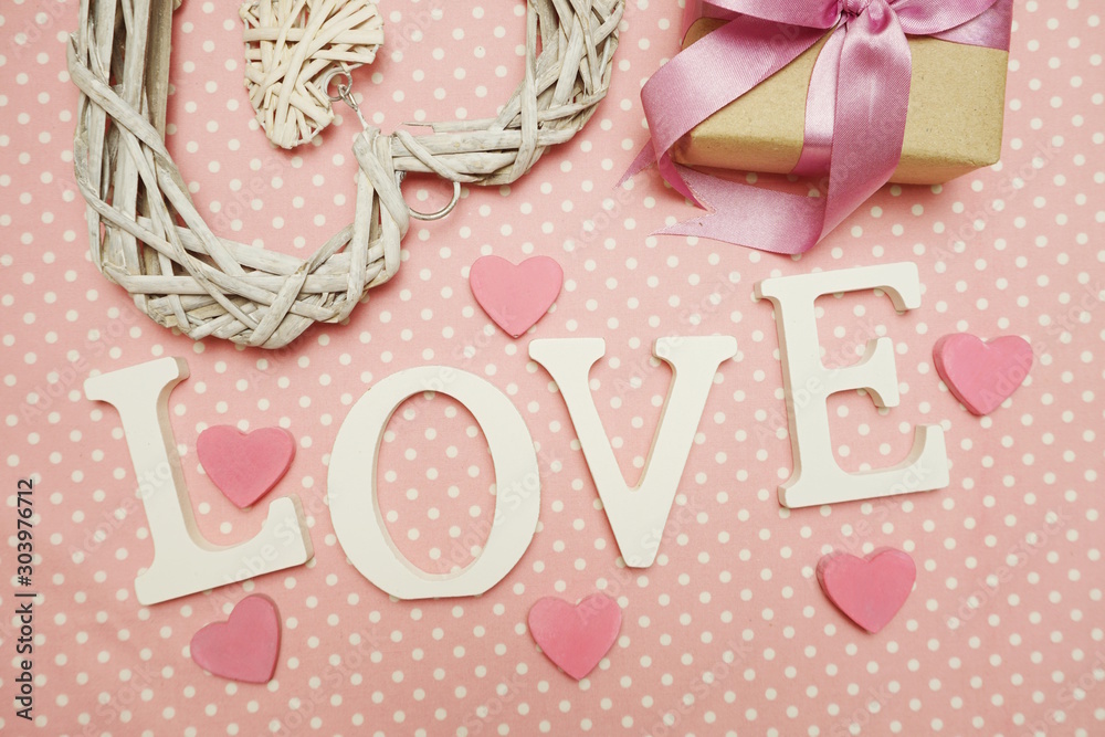 Love word alphabet and Gift box with roses bouquet with space copy on pink polka dot background Love word alphabet and Gift box with roses bouquet with space copy on pink polka dot background