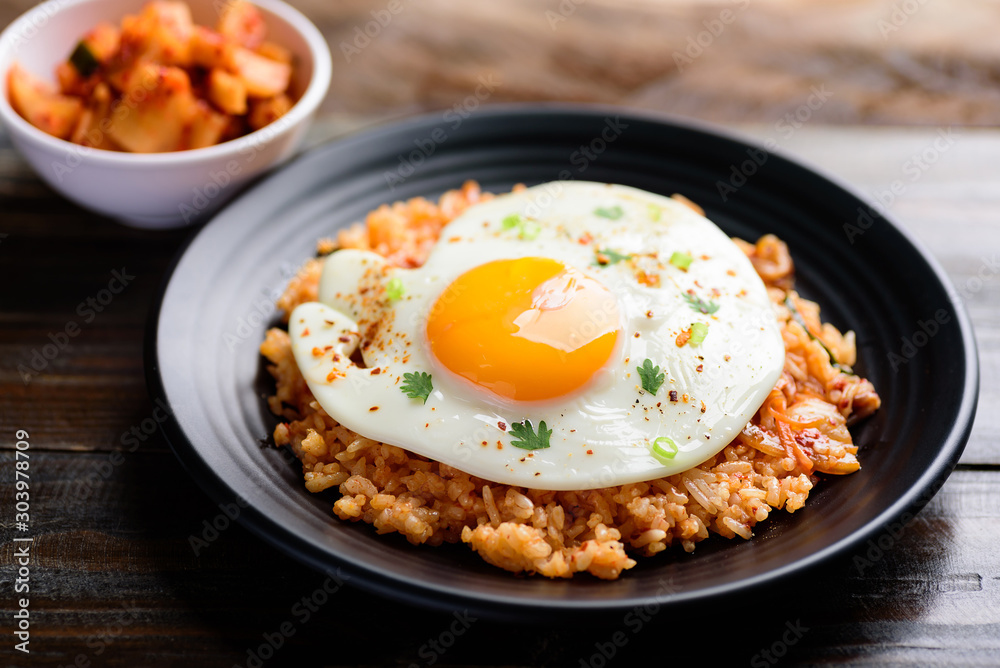 Kimchi fried rice with fried egg on top and fresh radish kimchi, Korean food Kimchi fried rice with fried egg on top and fresh radish kimchi, Korean food