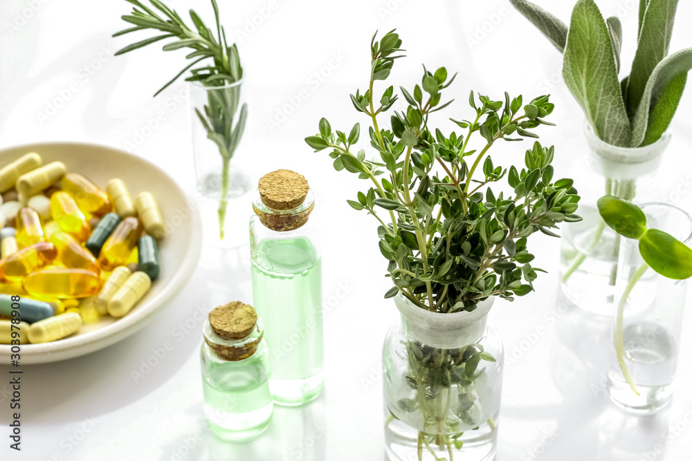 Healing herbs in glasses and medicine on white background Healing herbs in glasses and medicine on white background