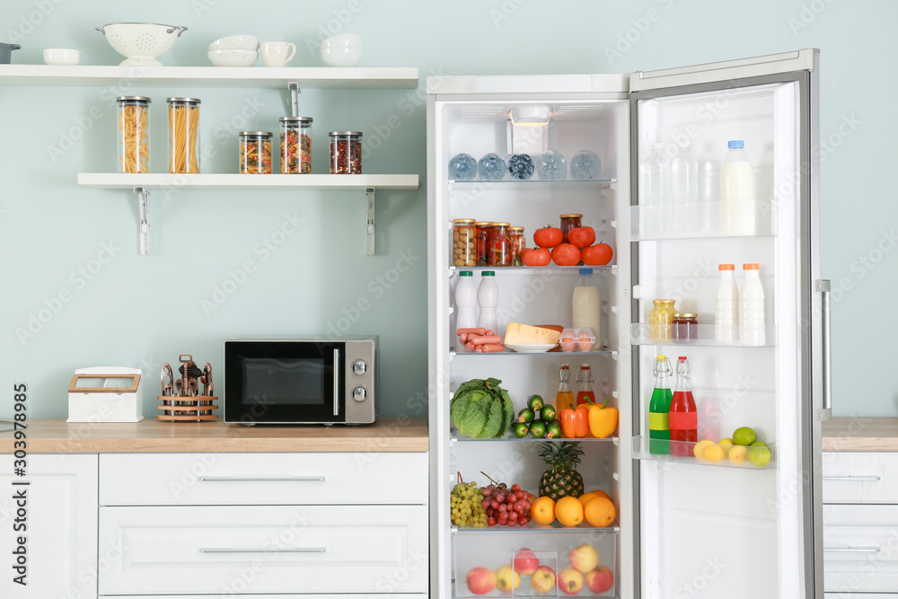 Open big fridge with products in kitchen Open big fridge with products in kitchen