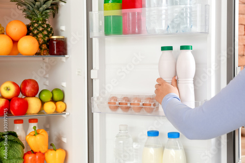 Woman taking food out of fridge