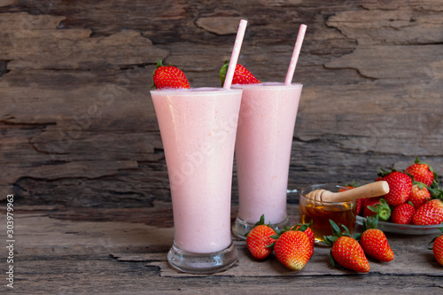 Strawberry yogurt fruit juice smoothie pink colorful fruit juice milkshake blend beverage healthy high protein the taste yummy In glass drink episode morning on wood background.