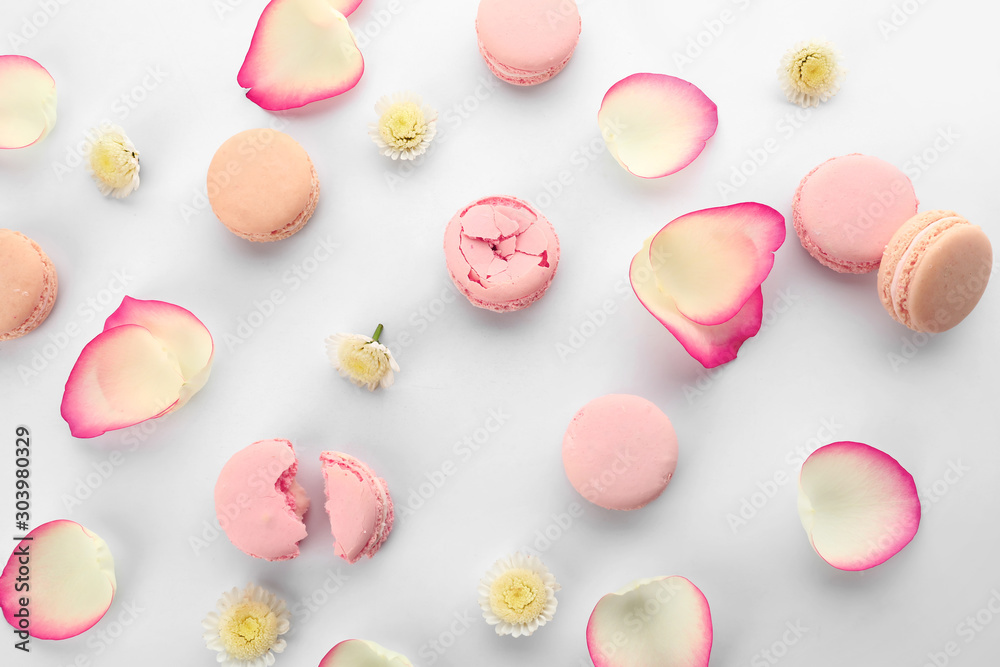 Different tasty macarons with flower petals on white background Different tasty macarons with flower petals on white background