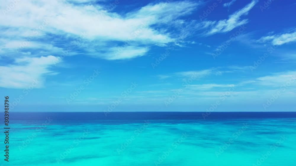 Paradise tropical seascape with white clouds on bright sky over navy blue ocean and turquoise lagoon in Caribbean, copy space Paradise tropical seascape with white clouds on bright sky over navy blue ocean and turquoise lagoon in Caribbean, copy space