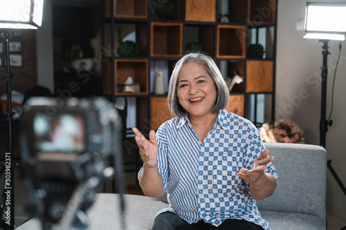 Confident women entrepreneurs recording vlog talking to camera photo