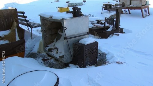 Garbage in abandoned ghost town of Gudym Chukotka of far north of Russia. Hopelessness in deserted city. photo