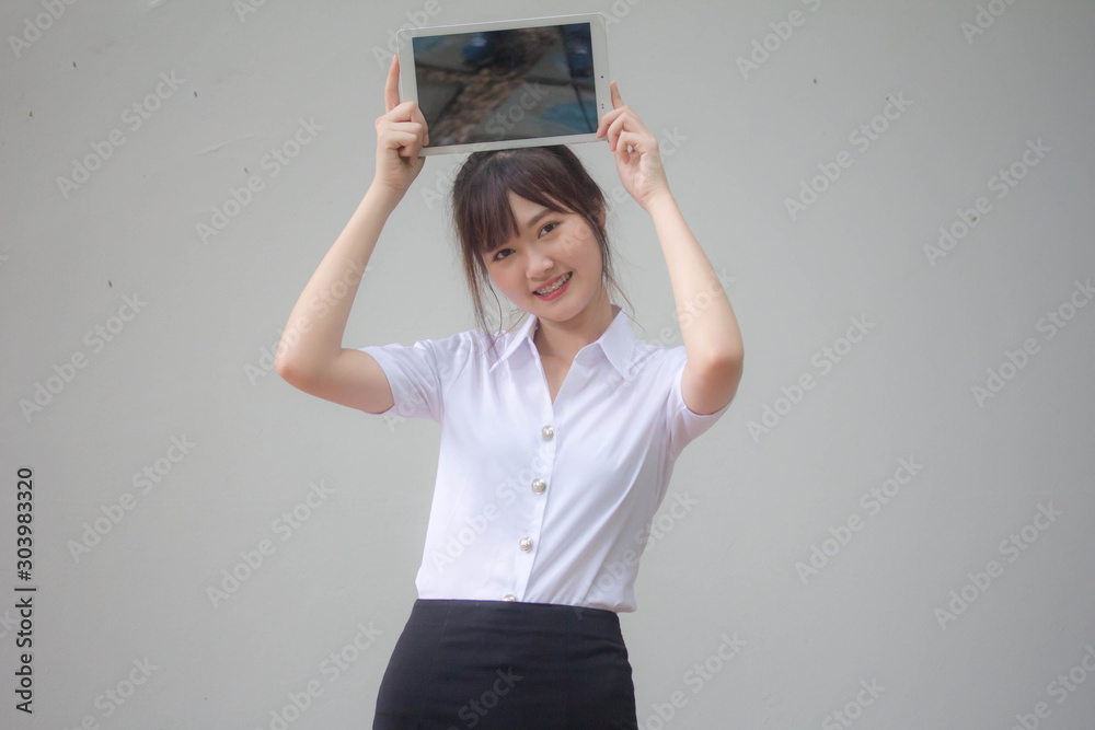 Φωτογραφία Portrait of thai adult student university uniform beautiful girl show her tablet