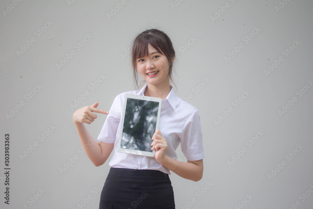 Φωτογραφία Portrait of thai adult student university uniform beautiful girl show her tablet