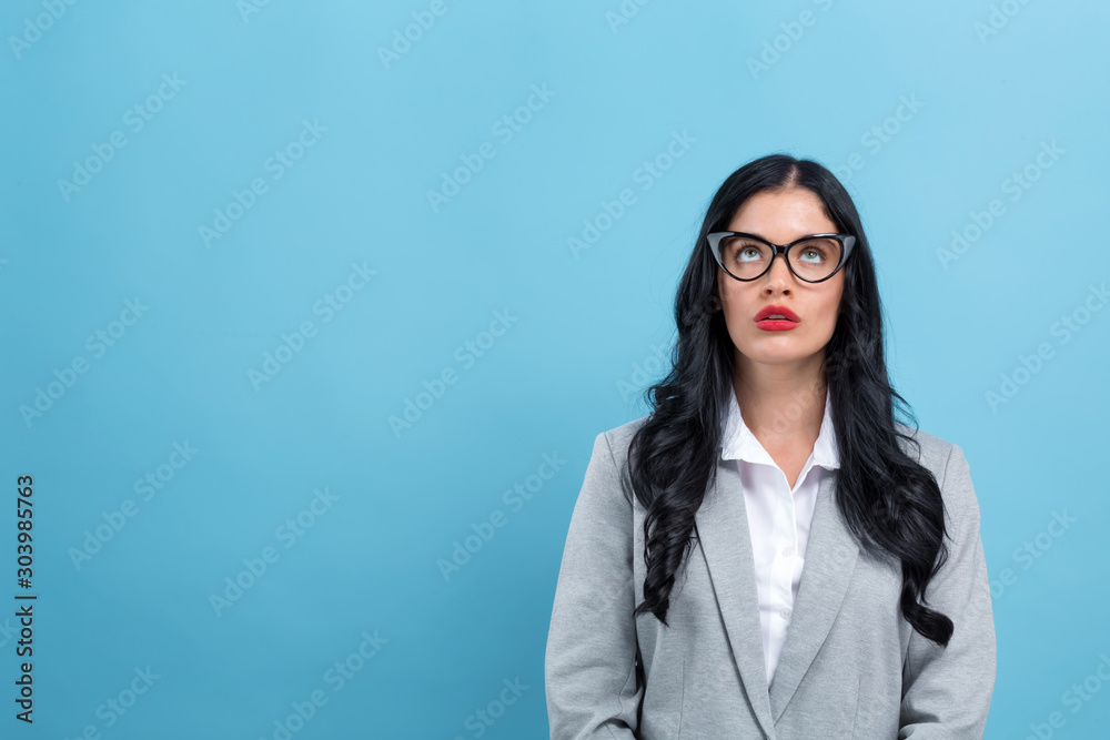 Young woman looking upwards on a blue background Young woman looking upwards on a blue background