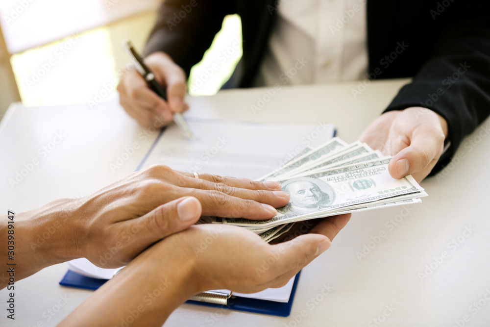 Money in the hands of businessmen who are submitting to entrepreneurs to force the signing of contract documents about corruption concept. Money in the hands of businessmen who are submitting to entrepreneurs to force the signing of contract documents about corruption concept.