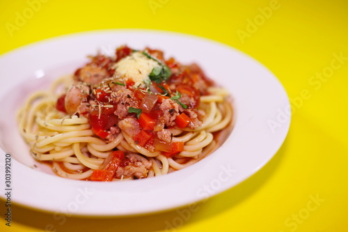 Spaghetti on a plate on a yellow background