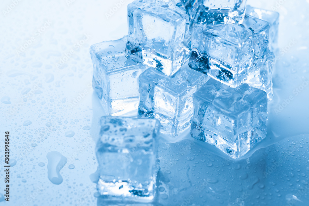Ice cubes square with drops water clean on blue background Ice cubes square with drops water clean on blue background