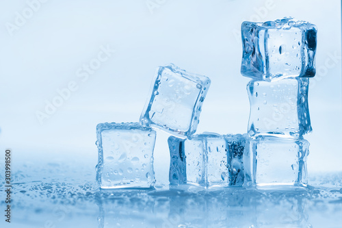 Ice cubes square with drops water clean on blue background