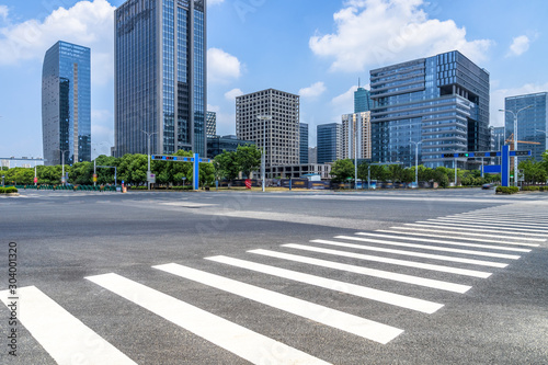 empty road with zebra crossing and skyscrapers in modern city.